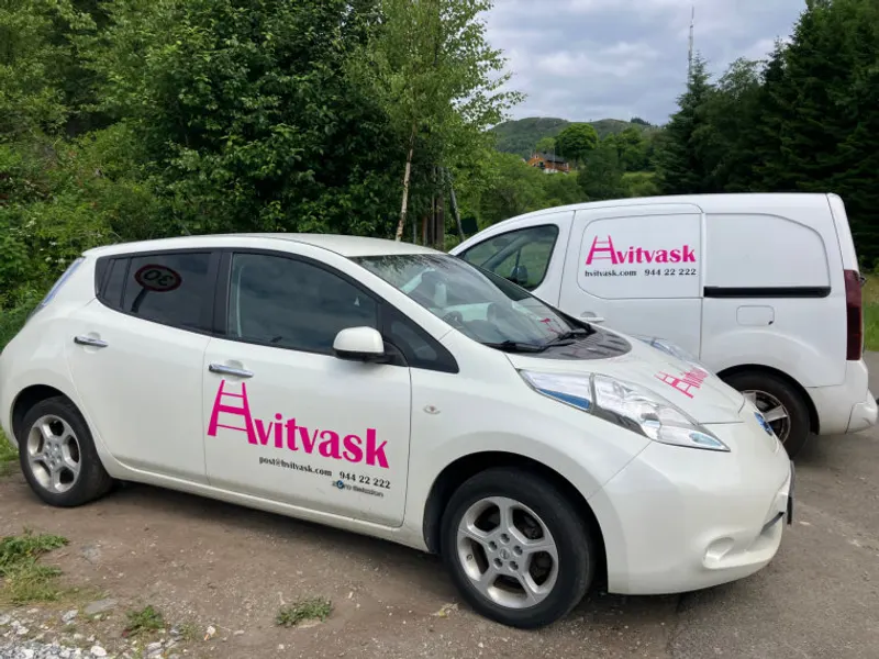 Hvitvask sine hvite servicebiler med magenta logo, klare for oppdrag i Bergen.