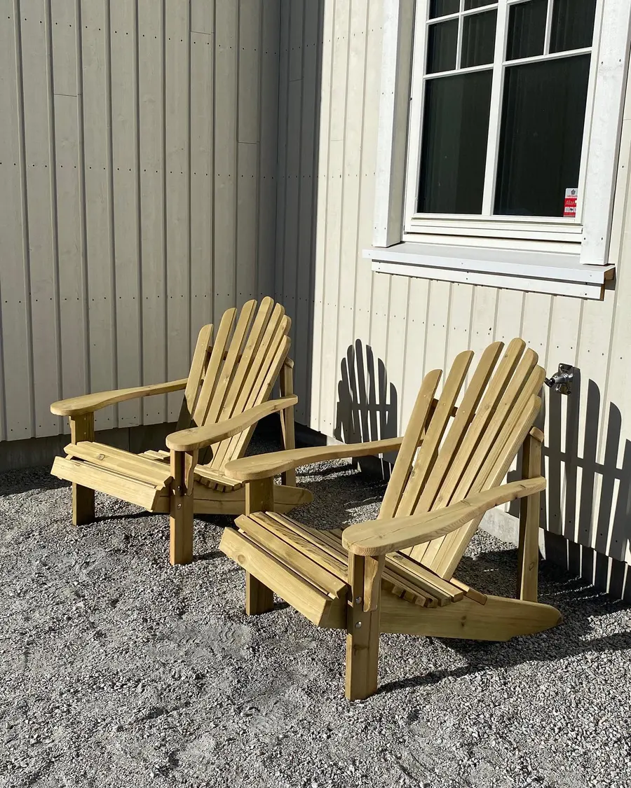Håndlagde utestoler i tre utendørs i solskinn.
